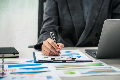 Wallpaper Mural A businesswoman works diligently at her desk, reviewing financial documents and analyzing investment data. She ensures accuracy and efficiency in financial calculations and audit processes. Torontodigital.ca