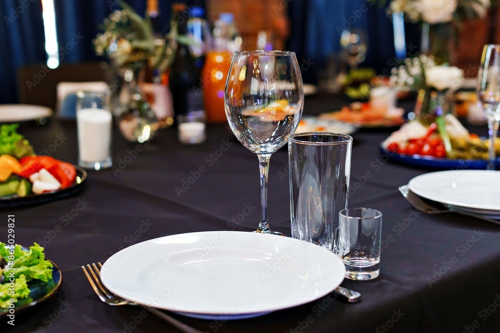 Empty glasses and a plate on a served banquet table. Catering. Empty glasses and a plate on a served banquet table. Catering.