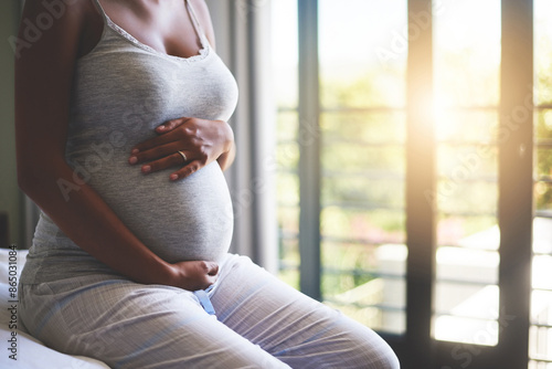 Woman, pregnant and hands on stomach for growth, bonding and maternal health as motherhood on bed. Mother, abdomen and pregnancy with care for feeling movement, connection and relax in home bedroom