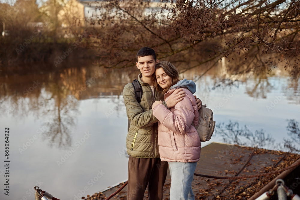 Embracing Moments: Beautiful 35-Year-Old Mother and 17-Year-Old Son in Winter or Autumn Park by Neckar River, Bietigheim-Bissingen, Germany Embracing Moments: Beautiful 35-Year-Old Mother and 17-Year-Old Son in Winter or Autumn Park by Neckar River, Bietigheim-Bissingen, Germany