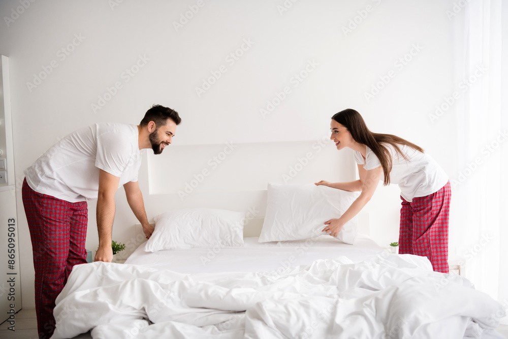 Photo of two people family couple make bed in morning house indoors Photo of two people family couple make bed in morning house indoors
