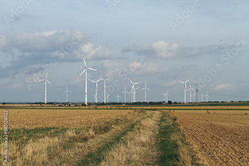 Wind turbines in an open field with cloudy sky in the background photo