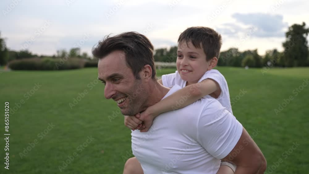 A joyous mixed race family spends a fun summer day together as the father carries his son on his back, showing happiness and strong bonding A joyous mixed race family spends a fun summer day together as the father carries his son on his back, showing happiness and strong bonding