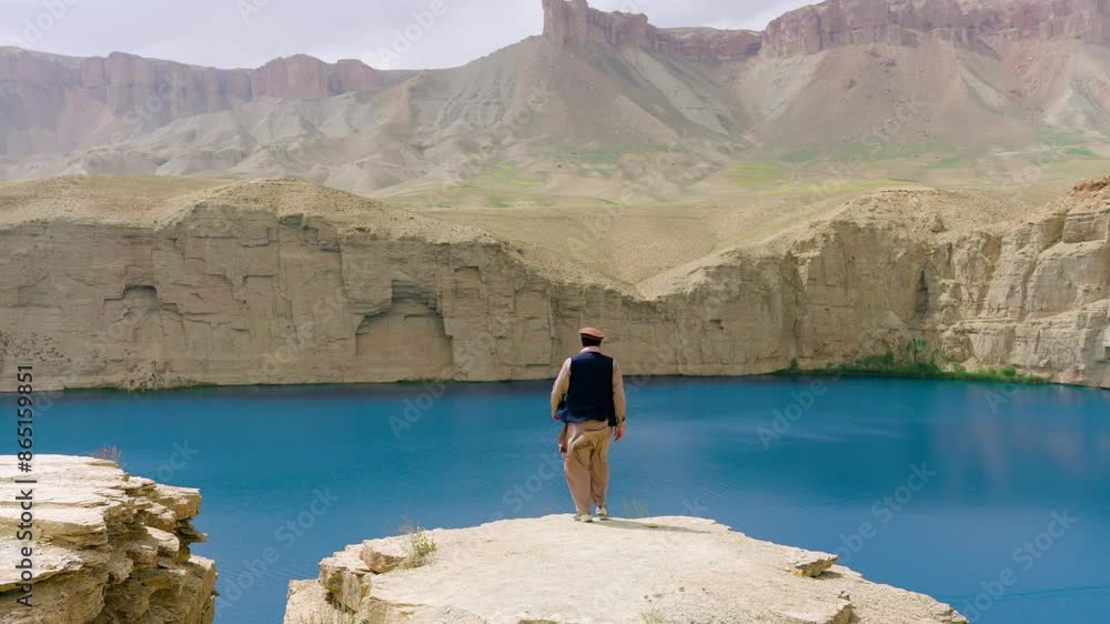 Revealed Afghan Man Over Cliffs Of Band-e Amir National Park In Bamyan, Afghanistan. Aerial Tilt-up Shot Revealed Afghan Man Over Cliffs Of Band-e Amir National Park In Bamyan, Afghanistan. Aerial Tilt-up Shot