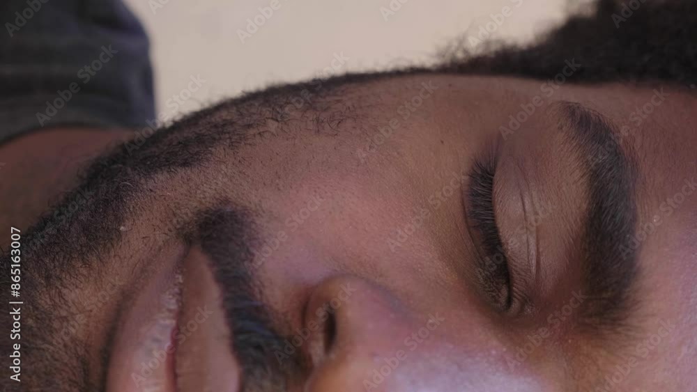 A powerful and captivating shot featuring half of a young Afro-descendant man's face as he gazes intensely into the camera, expressing depth and emotion. Vertical video A powerful and captivating shot featuring half of a young Afro-descendant man's face as he gazes intensely into the camera, expressing depth and emotion. Vertical video