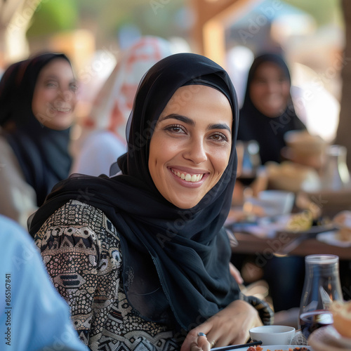 Happy saudi arabian woman sitting at cafe