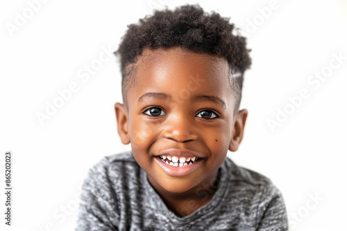 Cute African American preschool-aged boy with a charming smile, looking into the camera, isolated on white background.