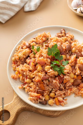 Jambalaya with rice chickpeas and kidney beans on beige table