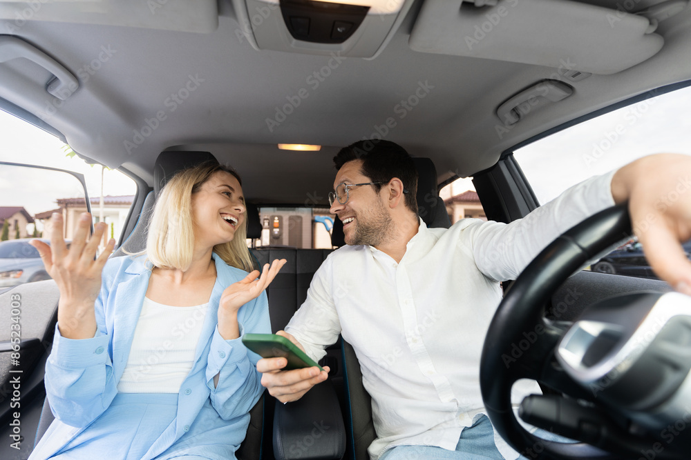 Smiling Couple Enjoying Road Trip In Car, Man Holding Phone, Engaging Conversation Smiling Couple Enjoying Road Trip In Car, Man Holding Phone, Engaging Conversation