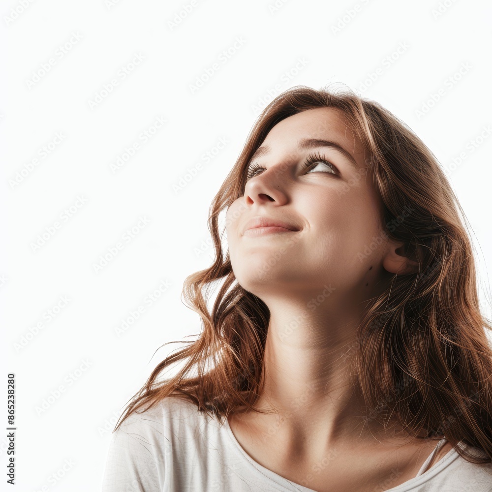 A young woman gazing upwards thoughtfully, a hopeful smile on her lips, on a white background. A young woman gazing upwards thoughtfully, a hopeful smile on her lips, on a white background.