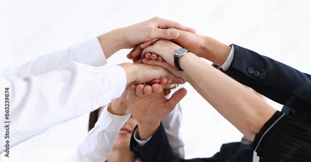 Obraz premium Group of people in suits crossed hands in pile for win closeup. White collar leadership high five cooperation initiative achievement corporate life style friendship deal heap stack concept