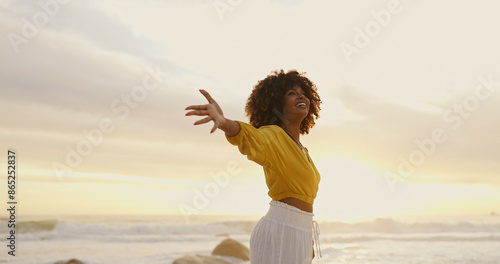 Sunrise, ocean and happy woman for freedom, vacation and holiday weekend in Miami with smile. Beach, african girl and carefree for adventure, peaceful and joy for sea breeze by scenic view outdoor