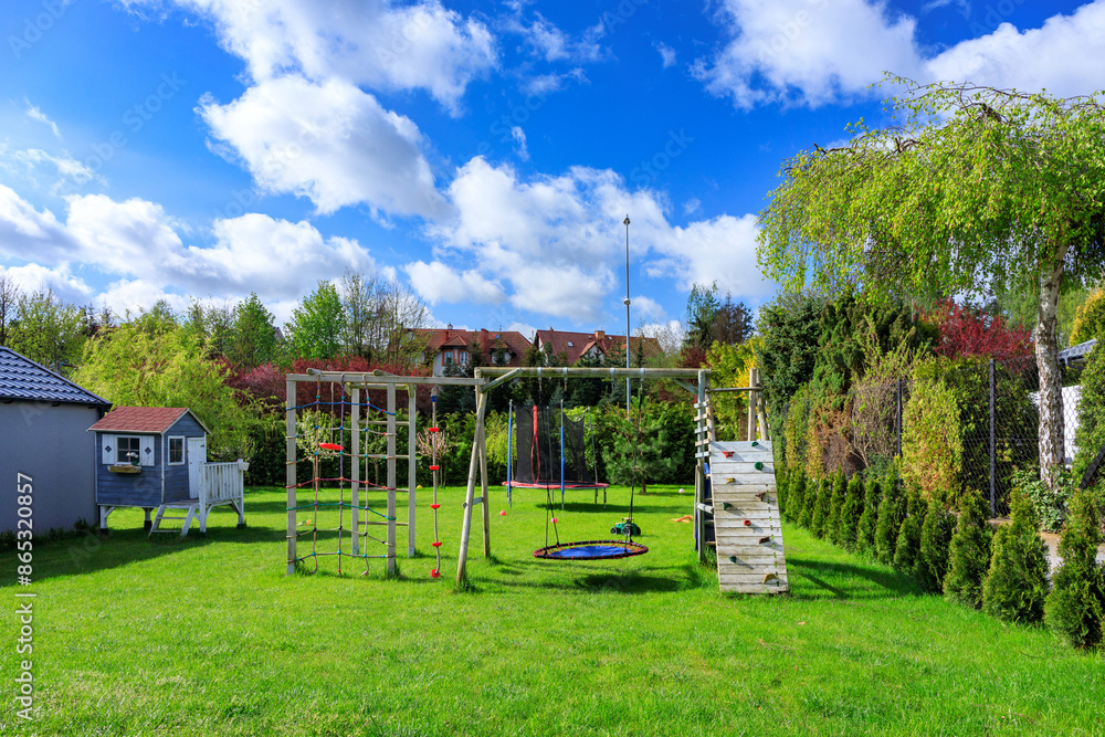 Φωτογραφία Green garden with a beautiful wooden house for children and a playground at spring