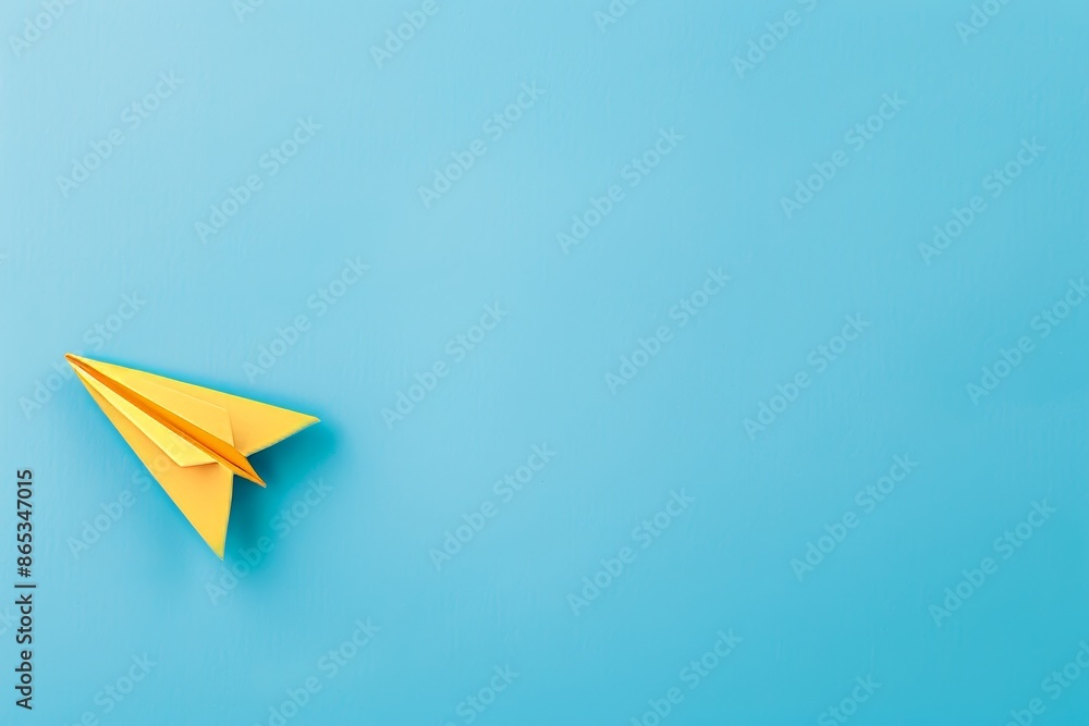 Fototapeta premium The top view photo depicts a yellow paper plane on a turquoise blue background with copy space and center composition.