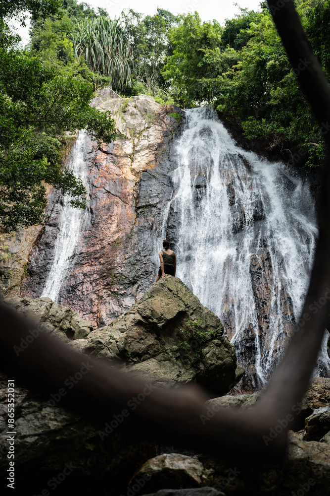 Stunning view of a girl in front of Na Muang Waterfall, Koh Samui, Thailand.