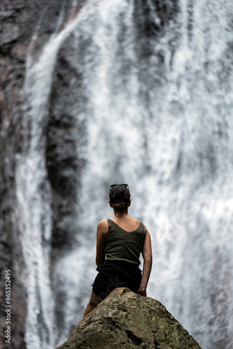 Stunning view of a girl in front of Na Muang Waterfall, Koh Samui, Thailand.