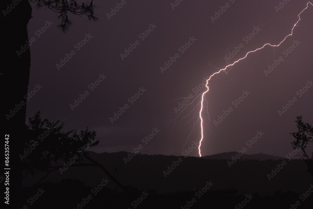 Stunning view of a lightning hit the ground during a thunderstorm in Italy.