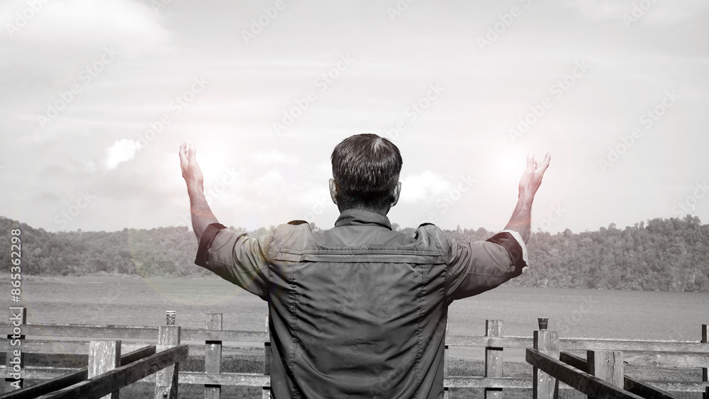 Man outstretched arms with light on the bridge in black and white background. Spiritual and grateful concept. Man outstretched arms with light on the bridge in black and white background. Spiritual and grateful concept.