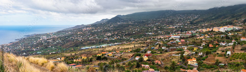 Fototapeta premium Panoramic view of the houses and villages of the island of La Palma at the foot of the volcanic mountains, Canary Islands.