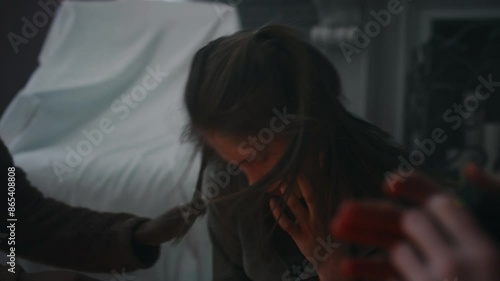 Side handheld shot of boy filming how demon possessing body of his girl friend. Teenager writhing, friends panicking and trying to help her in abandoned house
