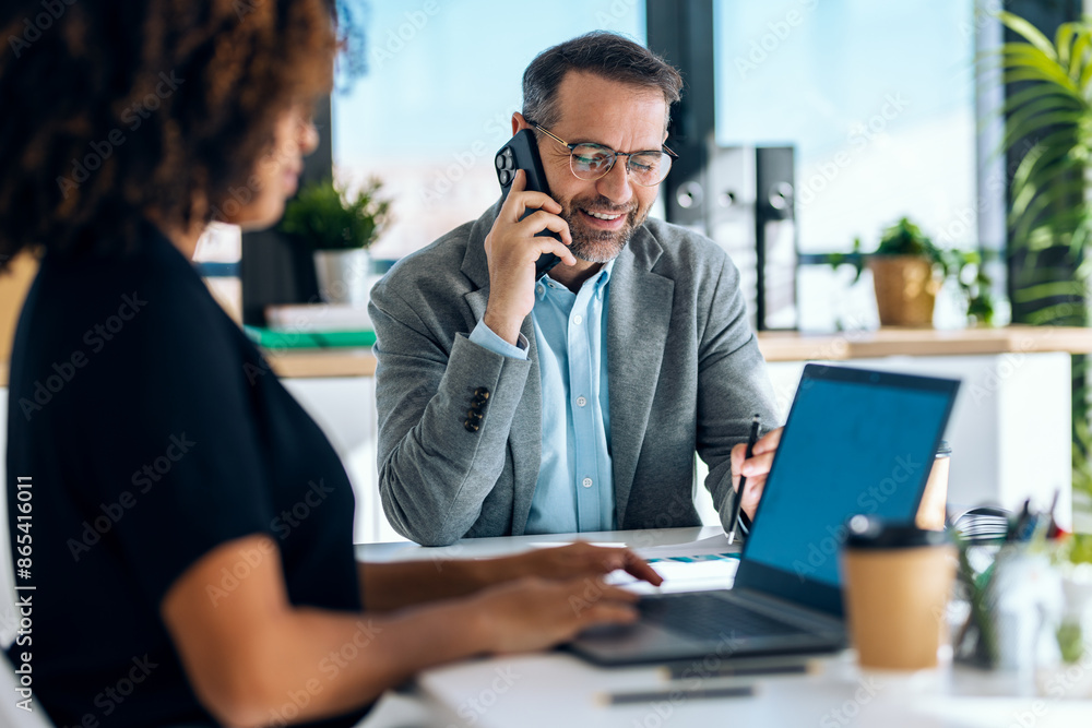 Elegant business people working together with laptop while talking in a modern office Elegant business people working together with laptop while talking in a modern office