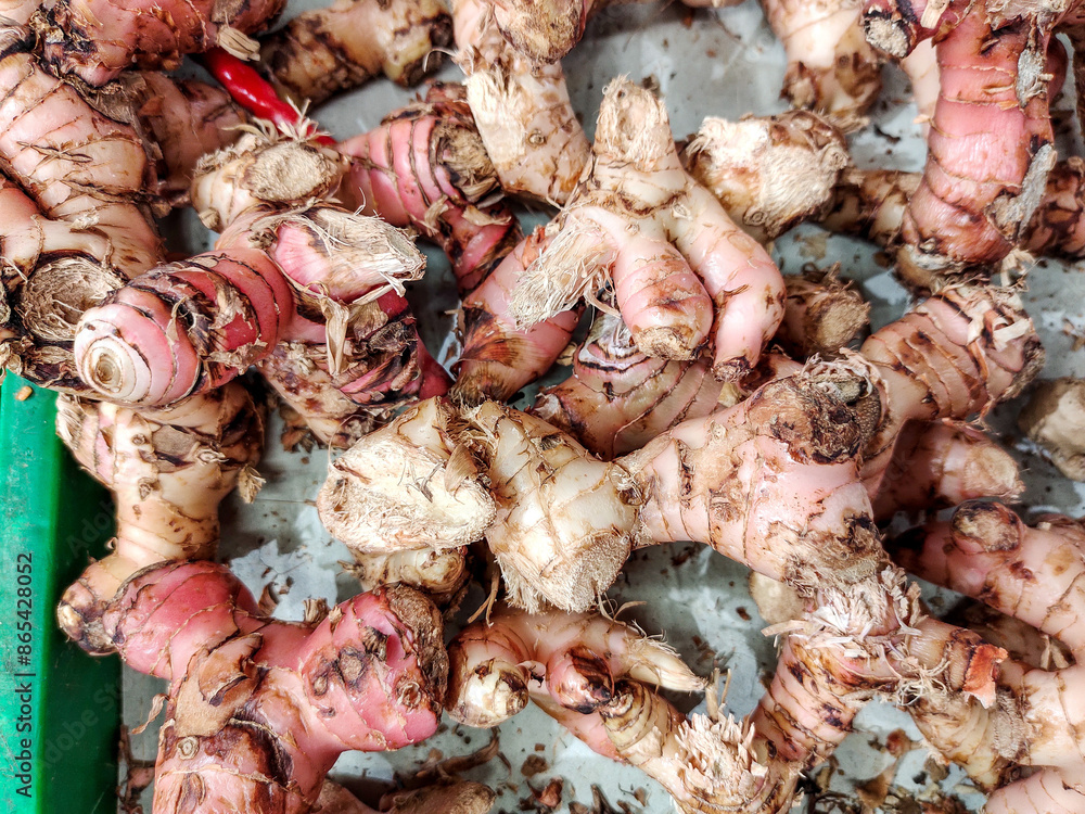 A stack of Galangal, a traditional spice widely used in Asian, especially Southeast Asian, cuisine, displayed in a traditional market stall A stack of Galangal, a traditional spice widely used in Asian, especially Southeast Asian, cuisine, displayed in a traditional market stall
