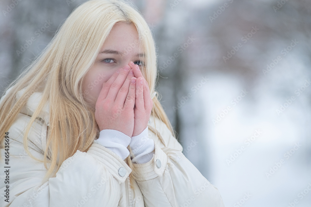Portrait of a young beautiful blonde girl outdoors in winter in cloudy weather. Portrait of a young beautiful blonde girl outdoors in winter in cloudy weather.