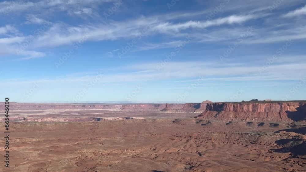 Slow panning shot of the iconic Canyonlands National Park from Grand View Point with beautiful blue sky and clouds. The vast landscape stretches out showcasing the beauty of nature - Utah, USA Slow panning shot of the iconic Canyonlands National Park from Grand View Point with beautiful blue sky and clouds. The vast landscape stretches out showcasing the beauty of nature - Utah, USA