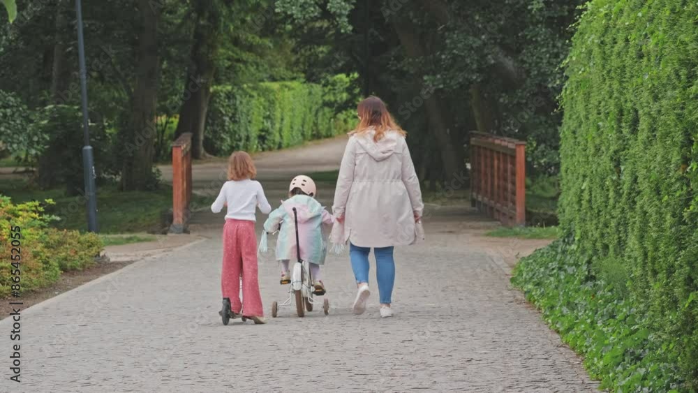 Caucasian Female Mother Spending Time with Kids on a Walk in City Park Caucasian Female Mother Spending Time with Kids on a Walk in City Park