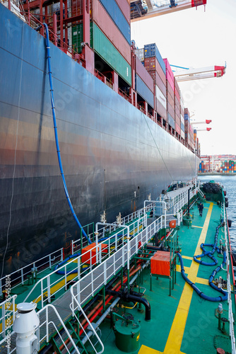 Ship refueling operation in port.