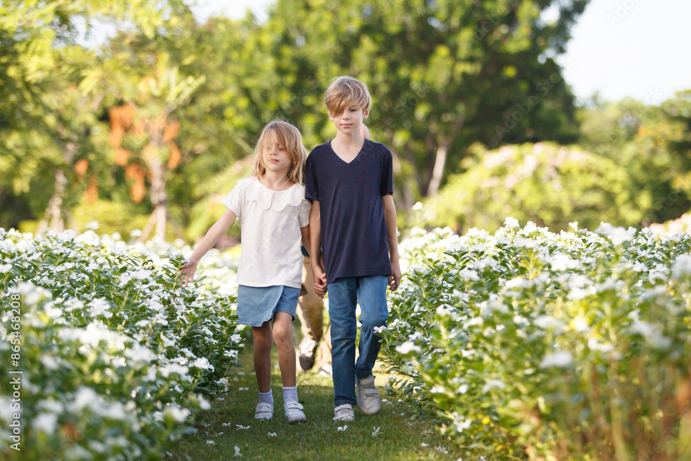 Fototapeta premium Caucasian white siblings playing at the park in morning.