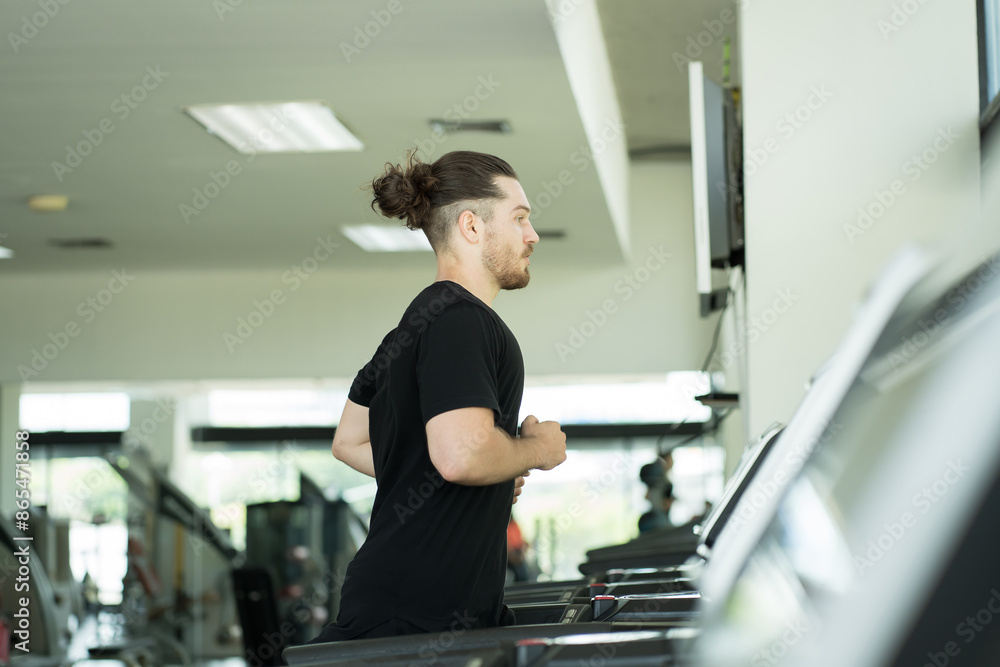 Man doing workout exercise by running on treadmill in gym. Man training hard in sport gym. Sport fitness concept Man doing workout exercise by running on treadmill in gym. Man training hard in sport gym. Sport fitness concept