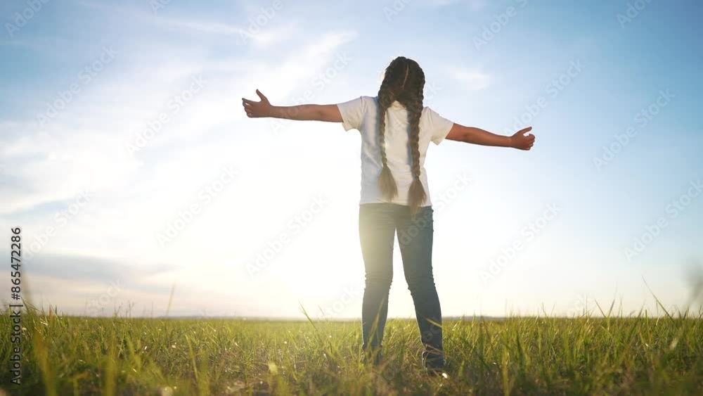 The free child's arms are looking to the sky. Religion freedom unity with nature concept. Girl in nature and religion with the sun. Girl child praying hands to sides looking lifestyle up in nature. The free child's arms are looking to the sky. Religion freedom unity with nature concept. Girl in nature and religion with the sun. Girl child praying hands to sides looking lifestyle up in nature.