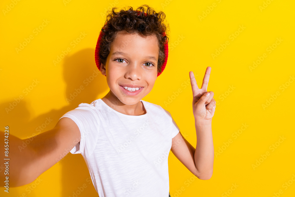 Photo portrait of cute little boy take selfie v-sign dressed stylish white clothes isolated on yellow color background Photo portrait of cute little boy take selfie v-sign dressed stylish white clothes isolated on yellow color background