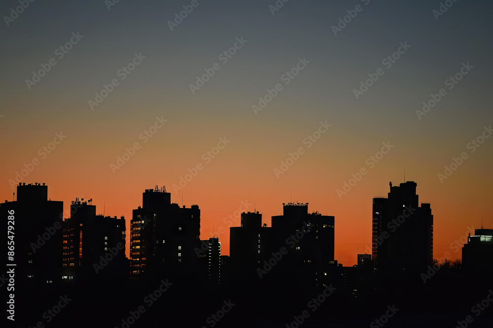 Fototapeta premium a city skyline with the sun setting behind it