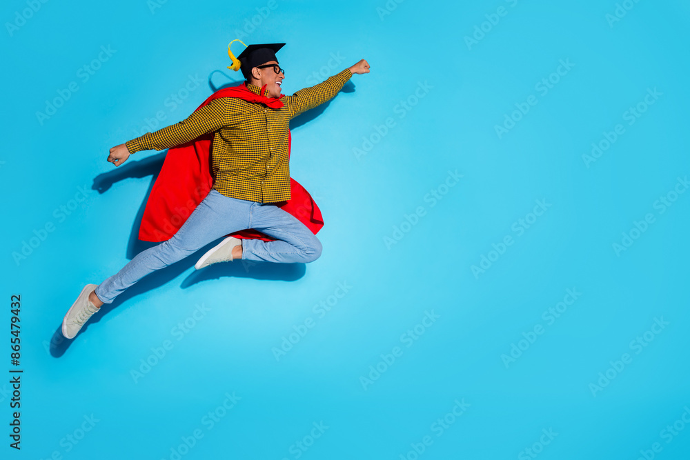 Fototapeta premium Full body photo of attractive young man flying superhero graduation dressed stylish plaid clothes isolated on blue color background