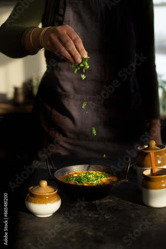 Adding garnish to a curry 