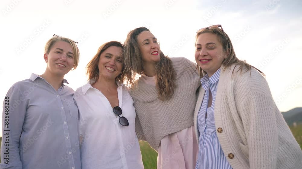 Four cheerful smiling women in sunglasses embracing laughing and looking at the camera during outdoor walking. Woman's friendship, relations, and happiness concept 4K footage. Four cheerful smiling women in sunglasses embracing laughing and looking at the camera during outdoor walking. Woman's friendship, relations, and happiness concept 4K footage.