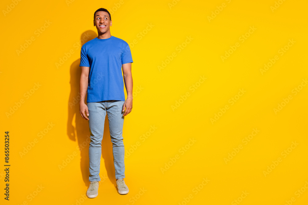 Full body photo of attractive young man look empty space dressed stylish blue clothes isolated on yellow color background Full body photo of attractive young man look empty space dressed stylish blue clothes isolated on yellow color background