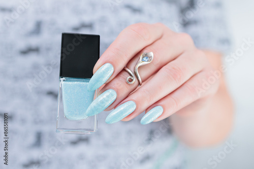 Woman's beautiful hand with long nails and light baby blue manicure	 photo