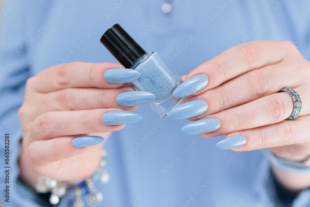 Woman's beautiful hand with long nails and light baby blue manicure Woman's beautiful hand with long nails and light baby blue manicure