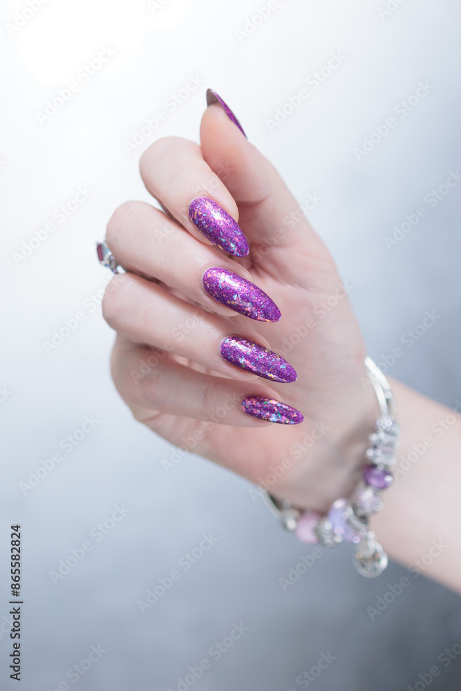 Female hand with long nails and purple plum manicure Female hand with long nails and purple plum manicure