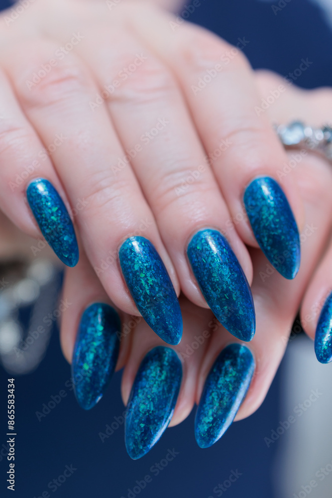 Woman's beautiful hand with long nails and bright blue manicure Woman's beautiful hand with long nails and bright blue manicure