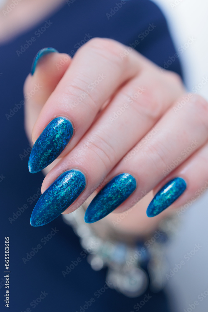 Woman's beautiful hand with long nails and bright blue manicure Woman's beautiful hand with long nails and bright blue manicure