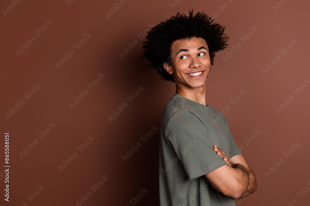 Photo portrait of nice young guy crossed hands look empty space turn around wear trendy khaki outfit isolated on brown color background Photo portrait of nice young guy crossed hands look empty space turn around wear trendy khaki outfit isolated on brown color background