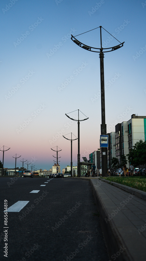 Street lamp poles, road, sunset sky Street lamp poles, road, sunset sky