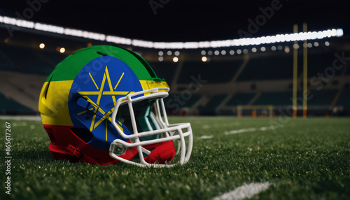 An American football helmet with the Ethiopia flag design sits on a field at night, under stadium lights