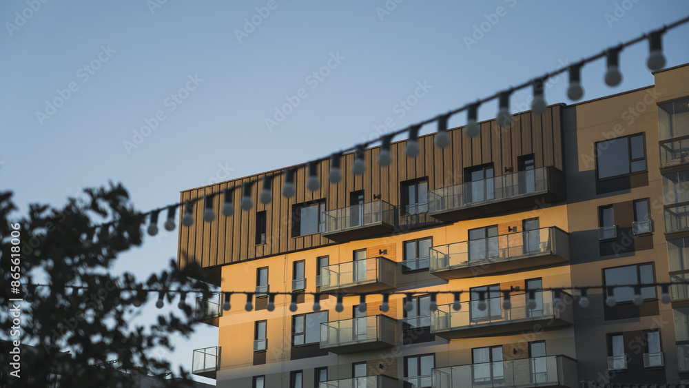 Obraz premium Modern residential building, against the background of the evening sky, and street lights