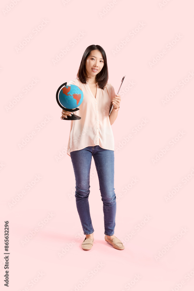 Asian Geography teacher with globe on pink background Asian Geography teacher with globe on pink background