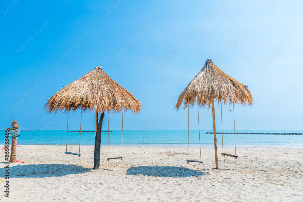 Beautiful swings under Nipa palm umbrella and beach with white sand of the sea on the beach blue sky with clouds on a hot sunny day background ,travel summer holiday Thailand Beautiful swings under Nipa palm umbrella and beach with white sand of the sea on the beach blue sky with clouds on a hot sunny day background ,travel summer holiday Thailand